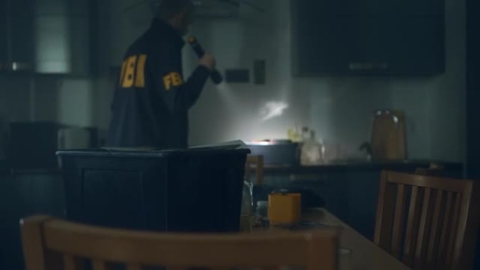 一个拿着手电筒的联邦调查局探员进入一间黑屋子检查罪犯的巢穴