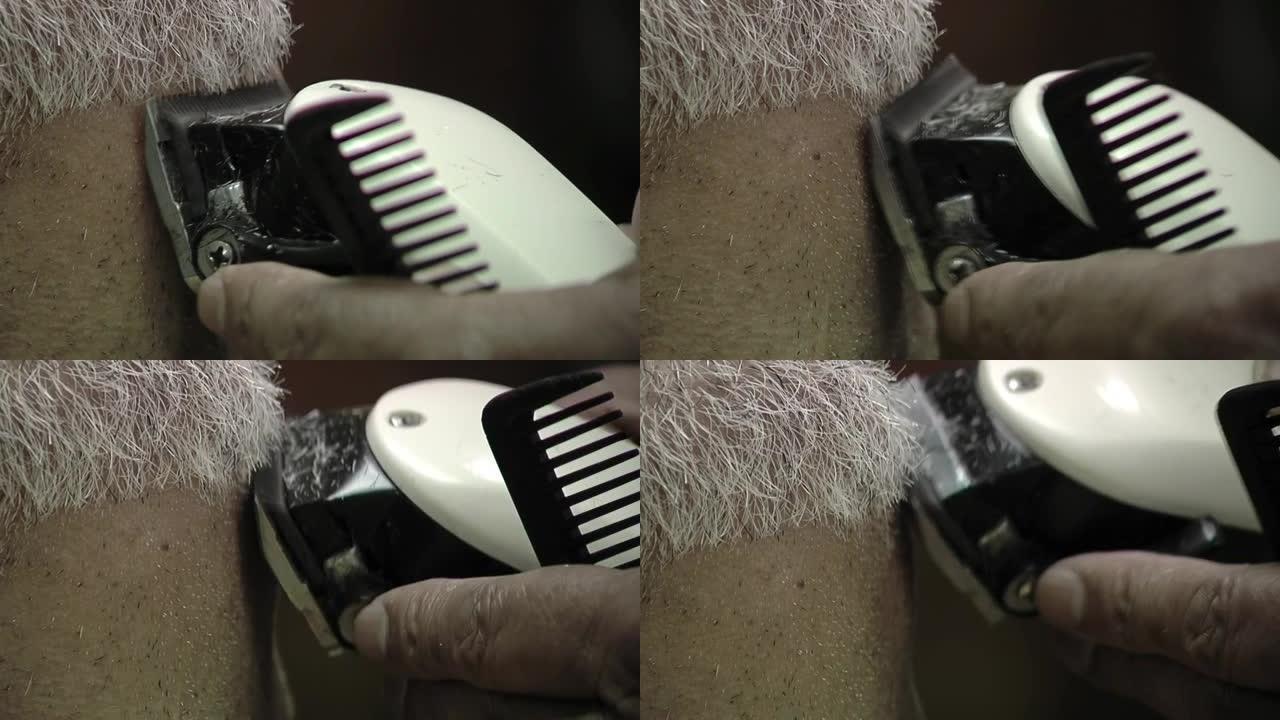 理发师用机器给坐在理发椅上的顾客理发。特写。