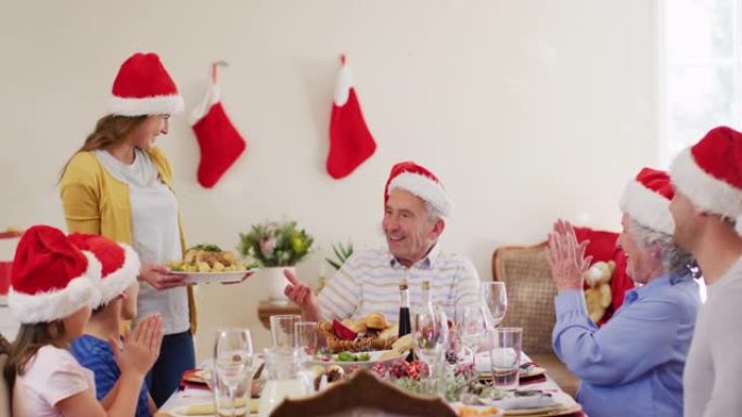 戴着圣诞老人帽子的白人妇女为全家人提供食物