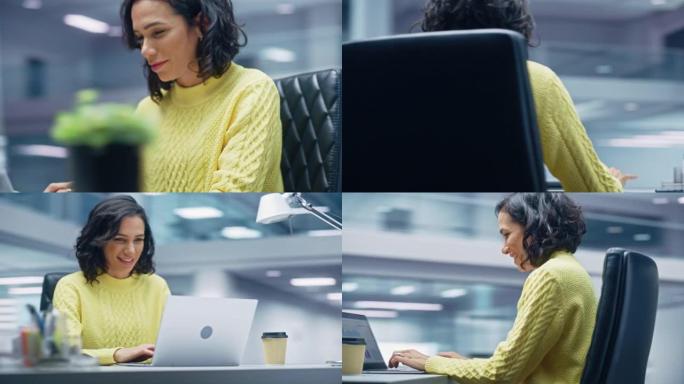 360学位办公室: 快乐微笑的西班牙裔女商人坐在她的办公桌上，在笔记本电脑上工作庆祝胜利。拉丁女企业