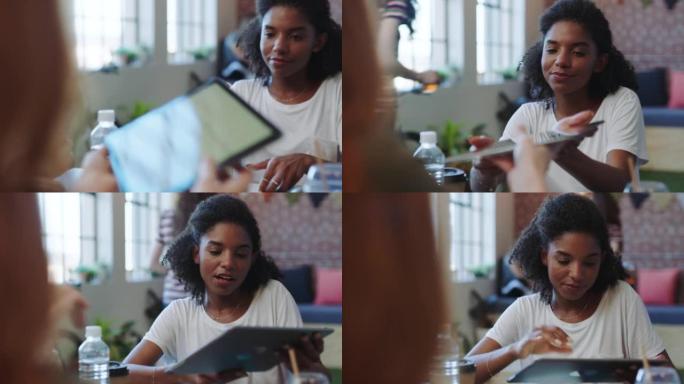 回顾，平板电脑和图表，与初创公司办公室的黑人女性一起进行营销，创新和指导。与小型企业公司员工的数字、