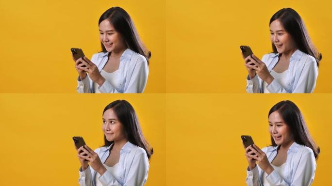 年轻女子在黄色背景下使用手机
