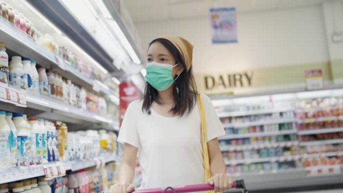 亚洲妇女戴着保护口罩购物。