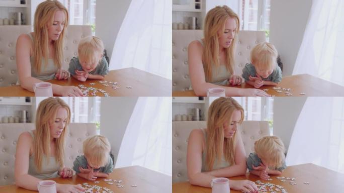 母女俩坐在家里的桌子旁玩得开心，一起做拼图游戏