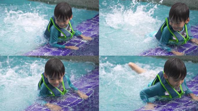 小男孩穿着救生衣在游泳池踢腿