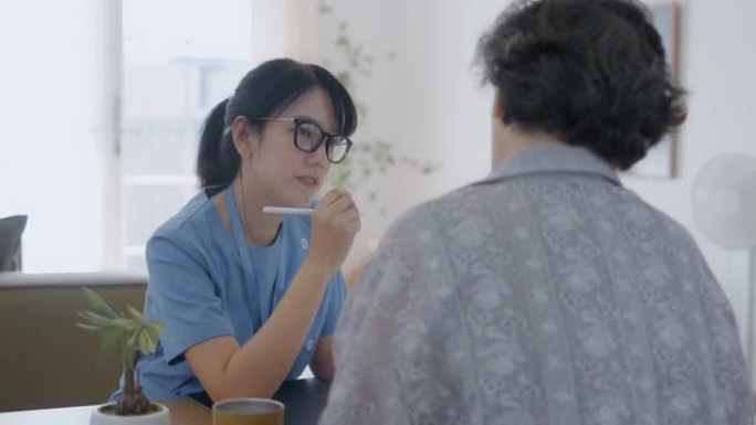 一位亚洲医生向小学年龄的高级妇女展示如何使用药物。