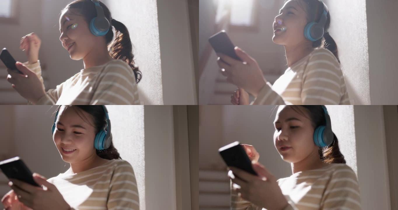 年轻的亚洲女人听音乐播客手机舞蹈享受家。