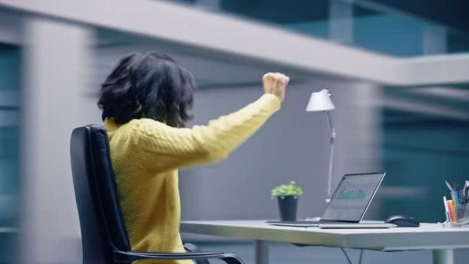 360度办公室: 快乐微笑的西班牙裔女商人坐在办公桌前在笔记本电脑上庆祝胜利。拉丁女企业家是成功的赢