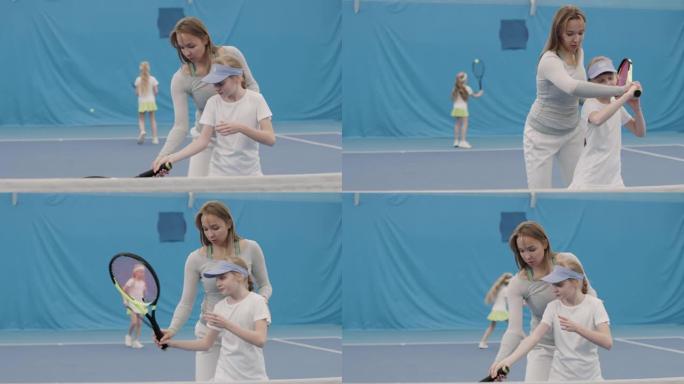 与教练一起进行网球训练的小女孩