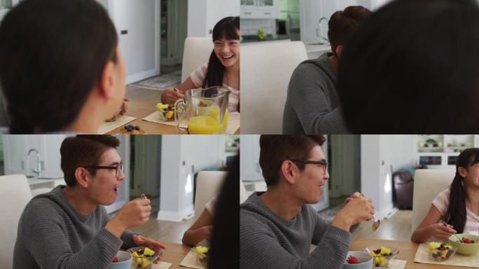 快乐的亚洲父母在厨房吃早餐，和笑女儿聊天