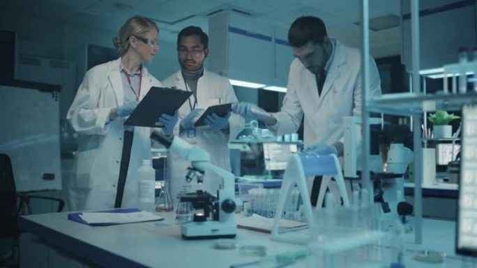 医学研究科学家团队在试管和平板电脑中的DNA样本的帮助下开会并进行实验。应用科学实验室，拥有多元多元
