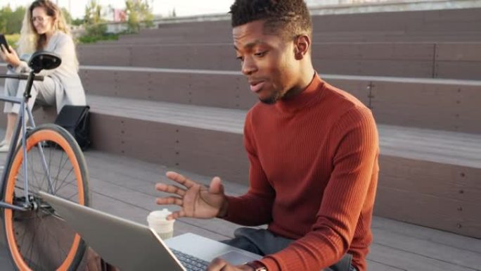 黑人男子在户外笔记本电脑上通过视频聊天聊天