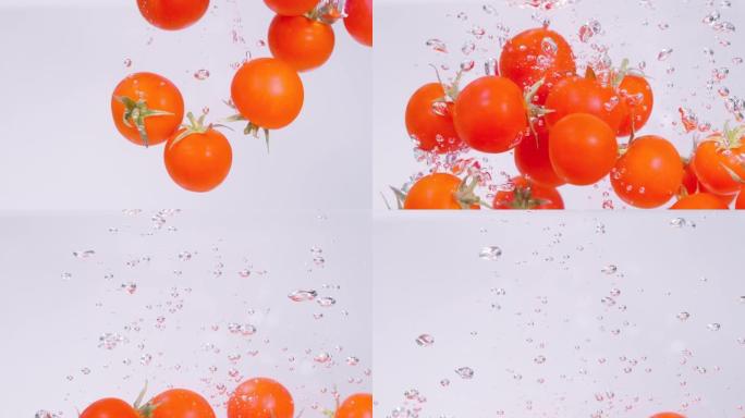特写: 充满活力的红色樱桃番茄落入清澈的淡水中。