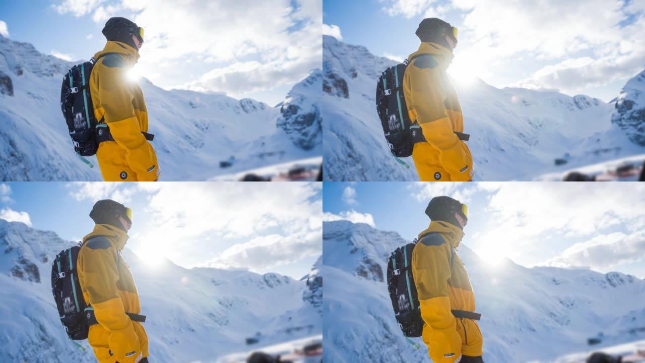 在一个美丽的阳光明媚的冬日里，被雪山环绕的滑雪者肖像欣赏冬季风景