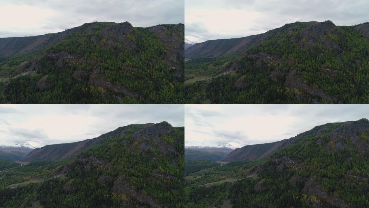 地平线上美丽明亮的森林雪山石峰。高全景飞行没有人在农村植物区系。旅游目的地田园诗般的自然。傍晚冒烟的