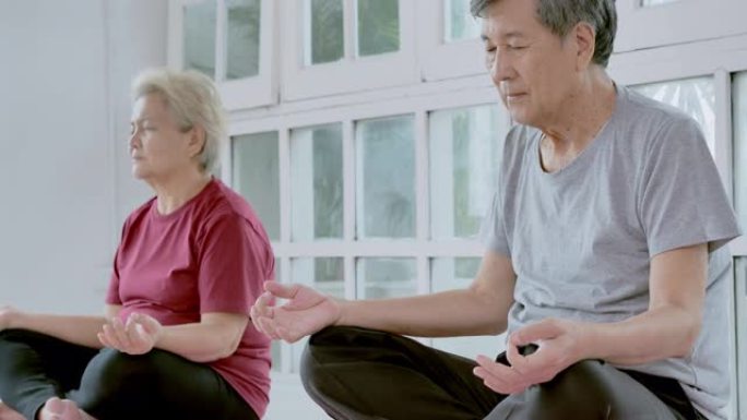 亚洲老年夫妇做瑜伽冥想家庭锻炼。家庭，生活方式，人，老年人，关系，退休，健康护理，领导，老年人在体育
