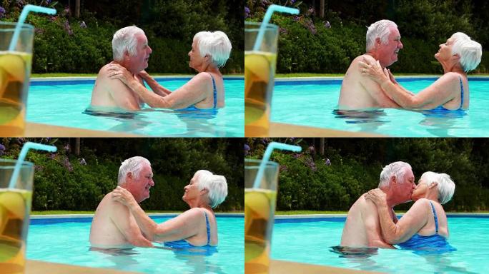 高级夫妇在游泳池里互相亲吻