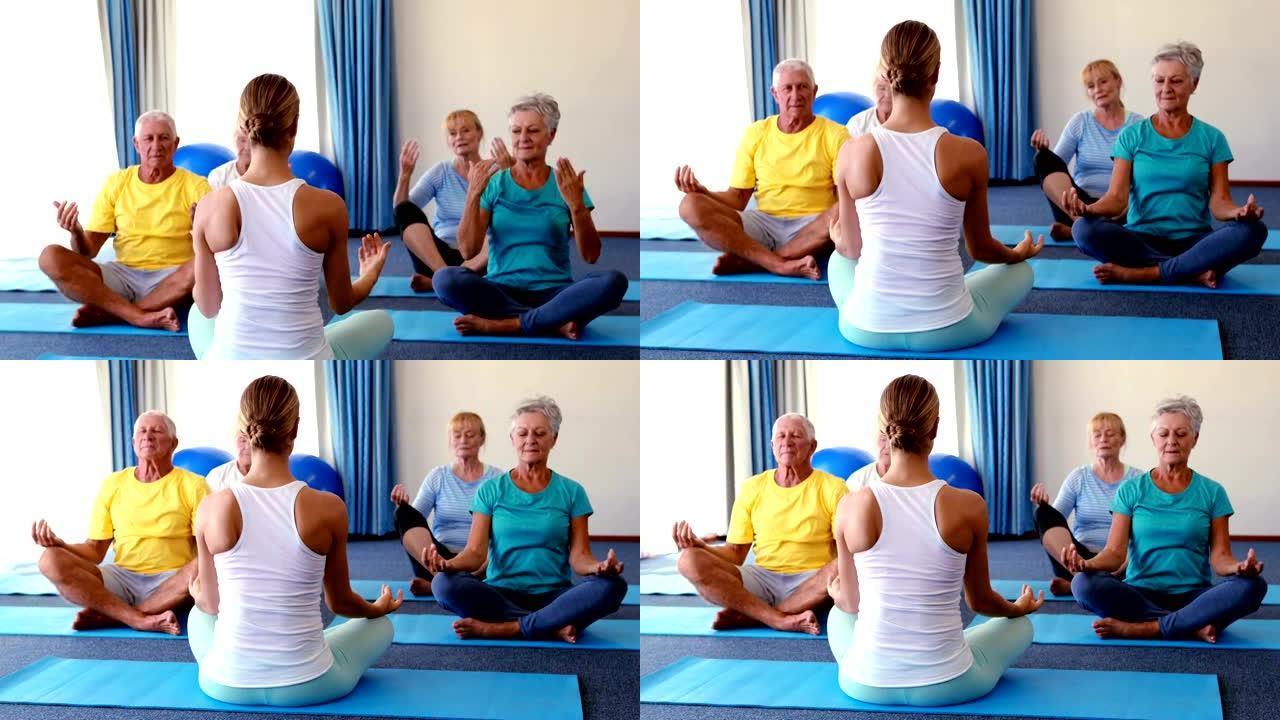 培训师协助老年人练习瑜伽
