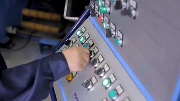 员工在工厂用控制按钮操作工业面板