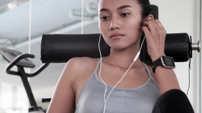 女人放松在健身房听音乐，放松