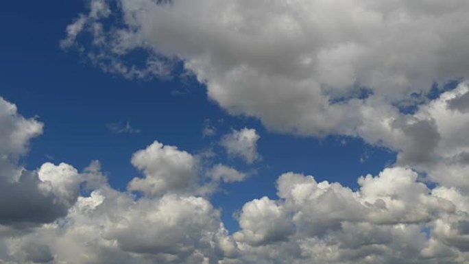 白色浮肿的云以延时的方式在蓝天上移动。天空背景