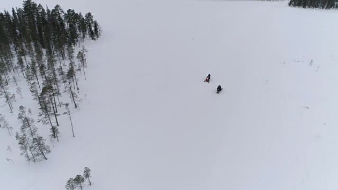 空中: 乘坐雪地摩托的游客探索白雪皑皑的冬季山坡