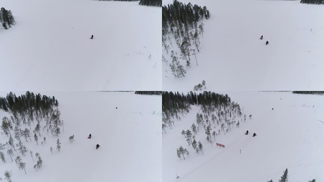 空中: 乘坐雪地摩托的游客探索白雪皑皑的冬季山坡