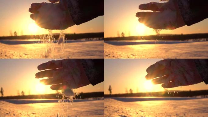 特写: 日落时分，雌性手在白雪皑皑的平原上滴下新鲜的柔软雪花