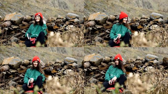山地冒险。在岩石上休息的年轻女子