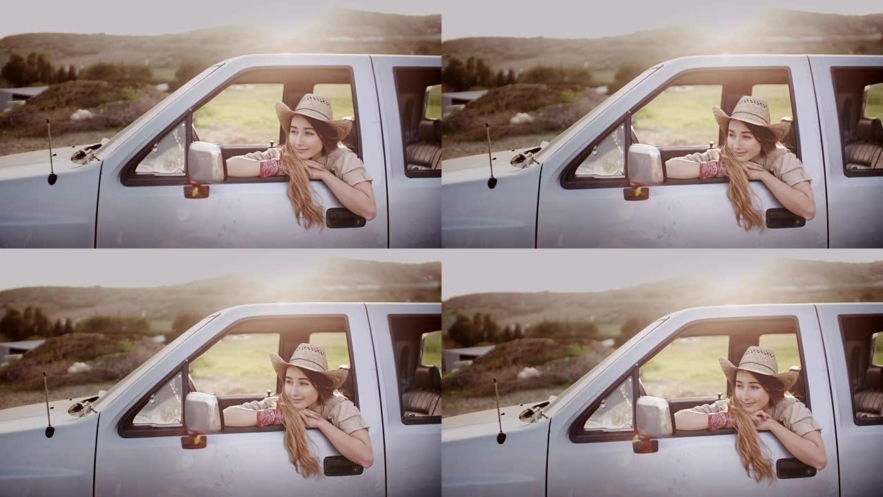 迷人的乡村女孩坐在农场的皮卡车上