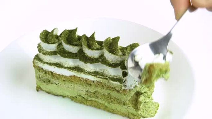 在白色背景上吃绿茶蛋糕。