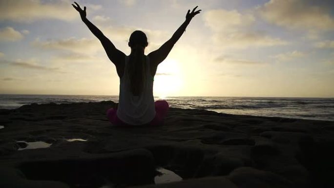慢动作自由快乐的女人在日落时做成功瑜伽姿势