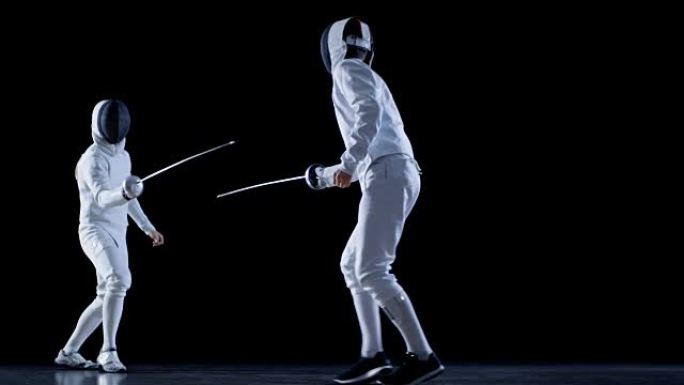 两名专业装备齐全的击剑手熟练地用箔纸战斗。他们进攻、防守、跳跃、推力和弓步。以慢动作和孤立的黑色背景