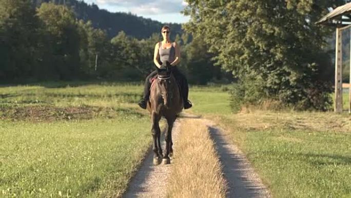 年轻开朗的女人在大自然中放松，骑着她的黑湾种马