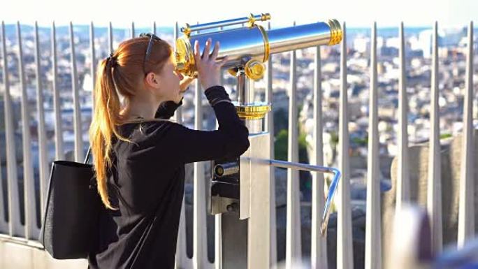 凯旋门顶上的游客通过双筒望远镜俯瞰巴黎