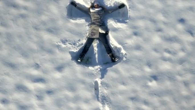 空中: 年轻女子在冬天做雪天使