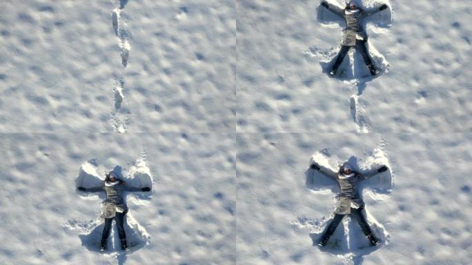 空中: 年轻女子在冬天做雪天使
