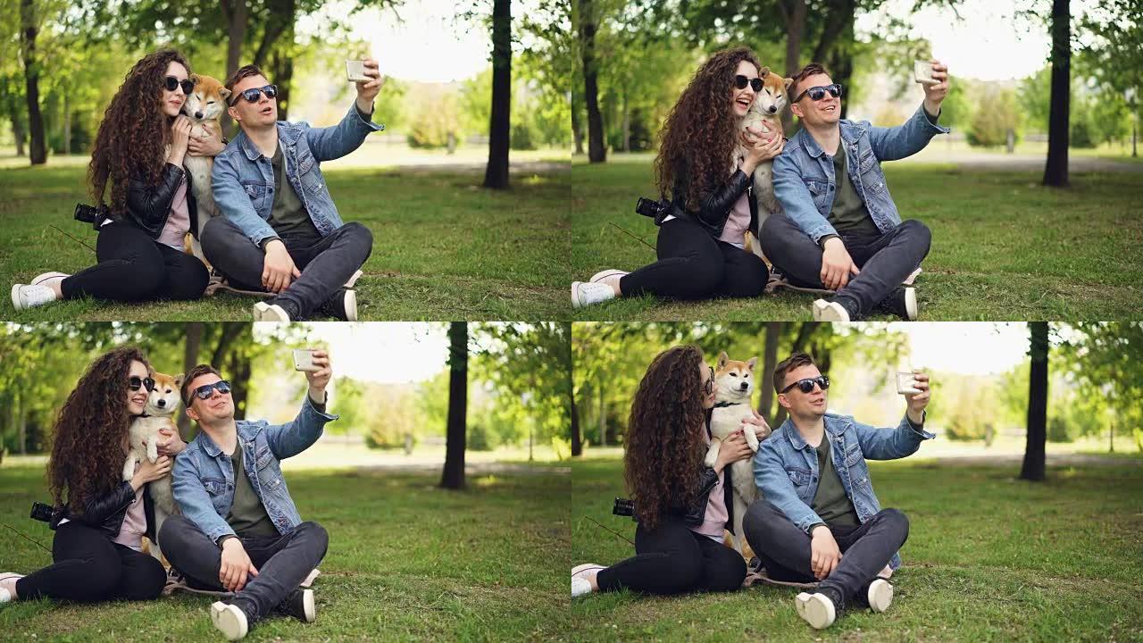 流行的博客作者正在录制有关他自己，他的妻子和可爱的狗的视频，男人拿着智能手机，说话，看着相机，然后对