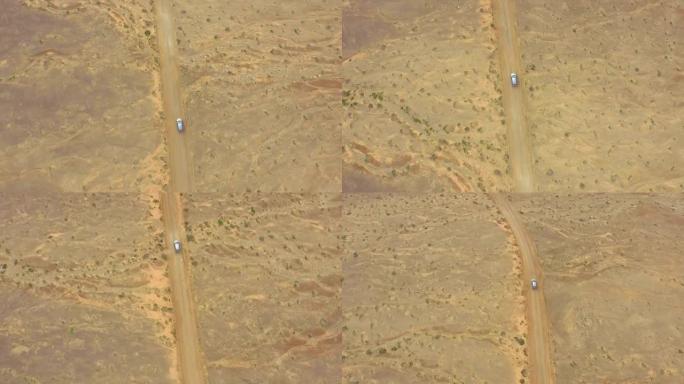 空中: 在汽车上方飞行，驶过巨大的沙质沙漠
