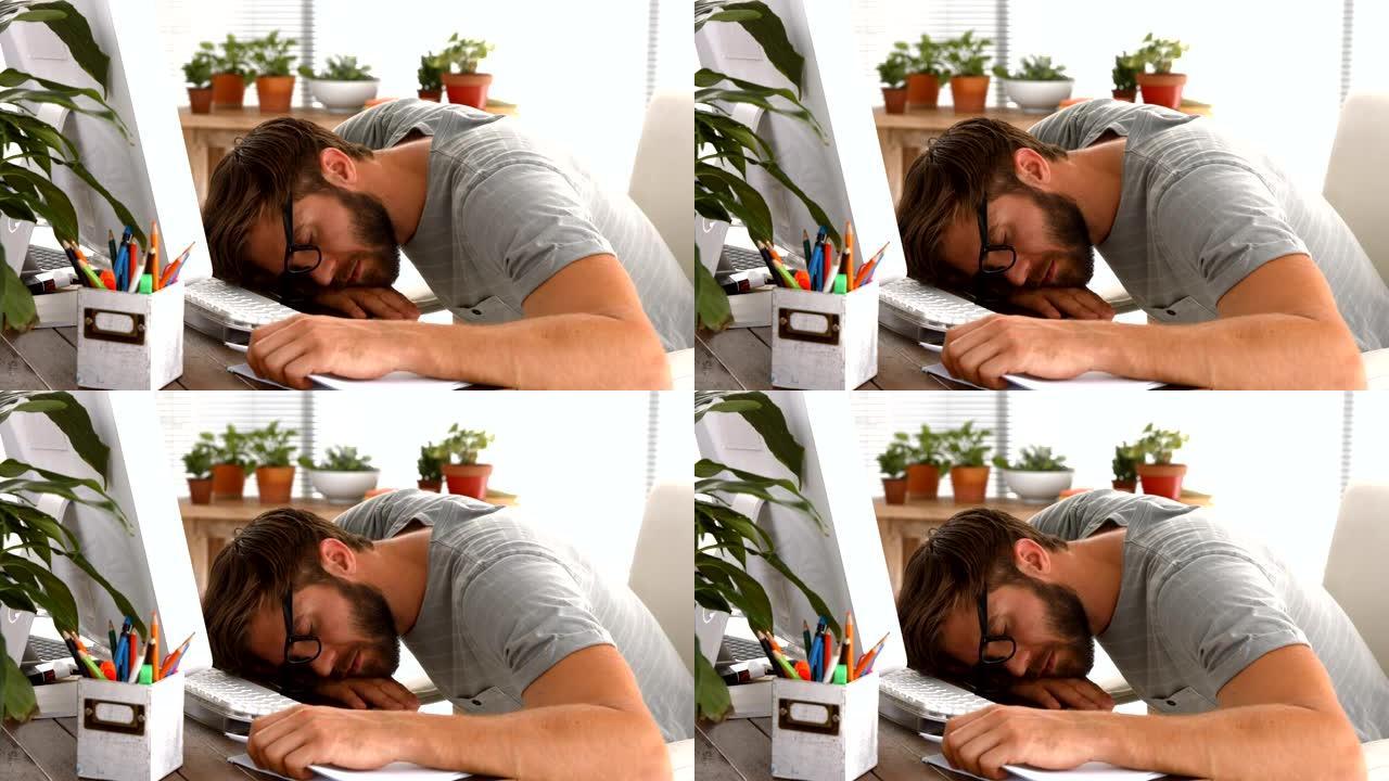 精疲力竭的商人睡在笔记本电脑上