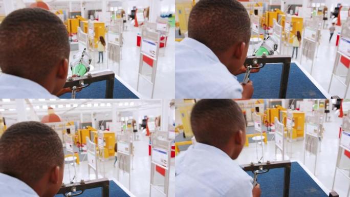 在科学中心使用气压火箭的年轻黑人男孩