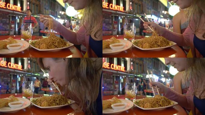 特写: 饥饿的年轻女子挣扎着用木筷子吃面条