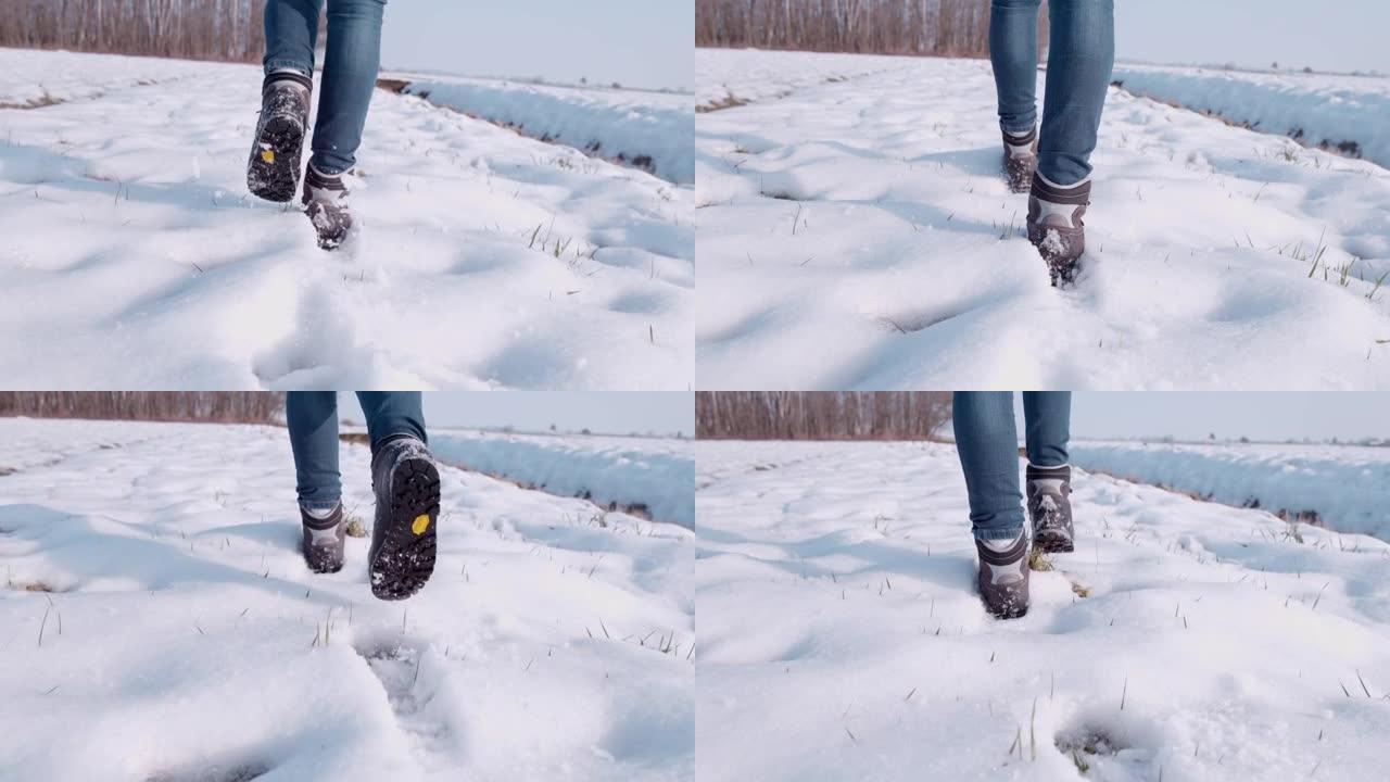 穿着靴子的徒步旅行者在阳光明媚的雪地里行走，超级慢动作