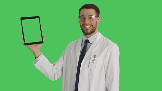 一位英俊的科学家戴着防护眼镜，用一只手拿着平板电脑，用另一只手滑动触摸手势。平板电脑和背景是绿色屏幕