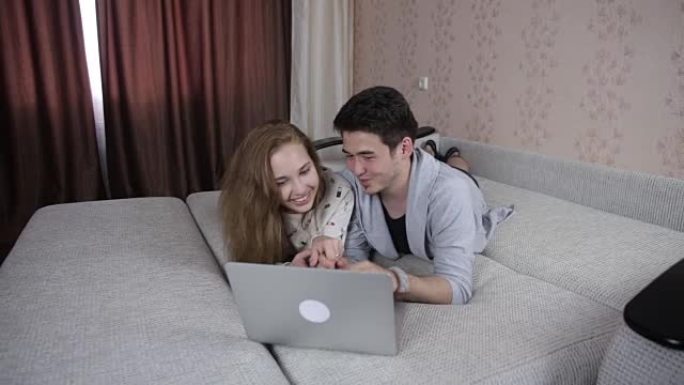 年轻夫妇在室内共享笔记本电脑