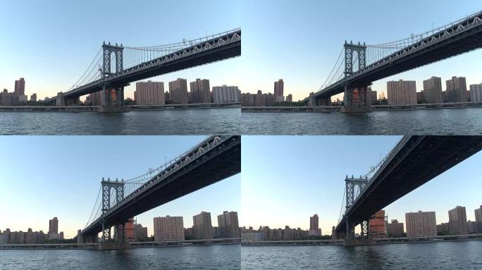 低角度视图: 黎明时沿着著名的曼哈顿大桥下的东河巡游