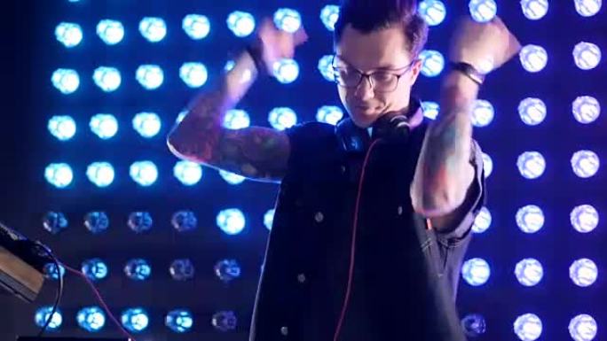 戴着黑框眼镜的DJ随着音乐跳舞。