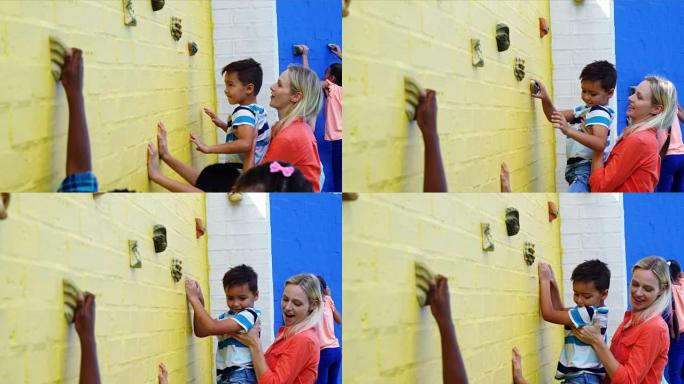 教练协助孩子们爬墙