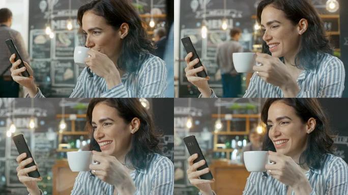 美丽的女人坐在咖啡馆里使用智能手机，她微笑着。在她端着饮料和羊角面包的桌上杯子上。在后台忙碌的时尚咖