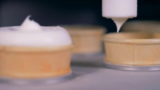 将威化饼杯装满白色冰淇淋的特写镜头。